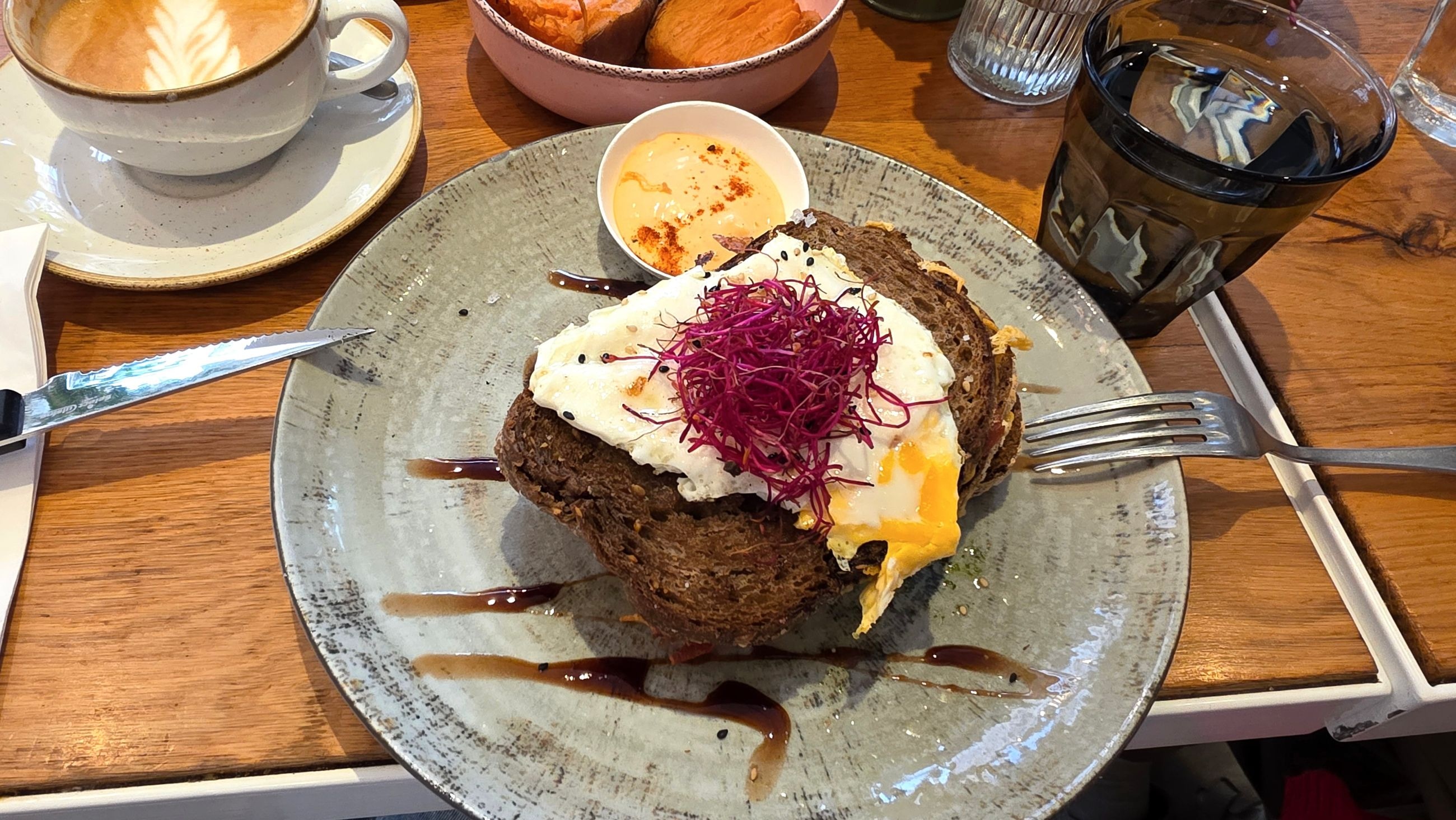 A loaded toast topped with a fried egg and pickled red cabbage, balsamic drizzle, at That's Toast
